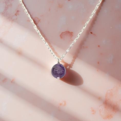1 cm Amethyst bead on an adjustable gold toned chain with a maximum length of 24 inches. 